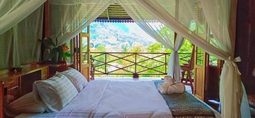 a bedroom with a bed with a teddy bear sitting on it at Camelliana Horizon Pongyang - Nature Retreat in Mae Rim