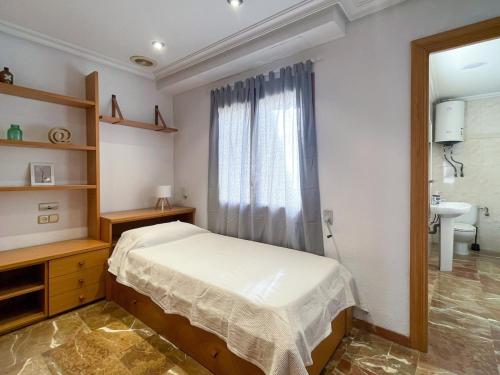 a bedroom with a bed and a sink and a window at Dúplex 2 plantas en Centro histórico de Elche in Elche