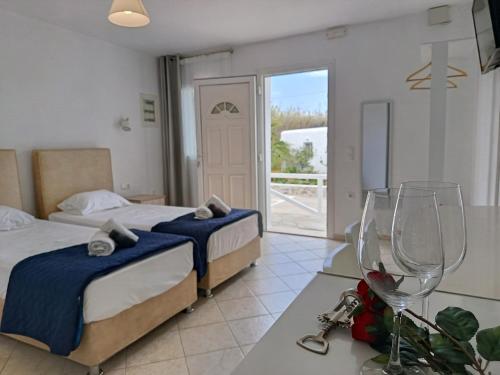 a bedroom with two beds and a table with wine glasses at NIKOLAS HOUSE CLOSE To TOWN in Mikonos