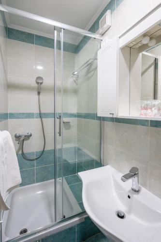 a bathroom with a sink and a glass shower at Hotel Adria in Neum