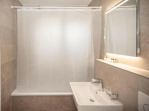 a white bathroom with a sink and a shower at FLC 11 Rooms in Rødby