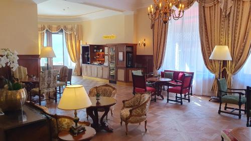 a living room with chairs and tables and a dining room at International au Lac Historic Lakeside Hotel in Lugano