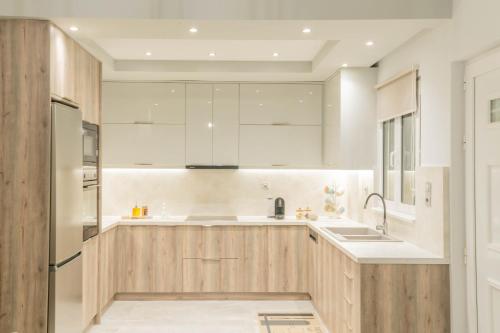 a kitchen with wooden cabinets and a refrigerator at Dafni Villa a place to visit by Rentado in Orné