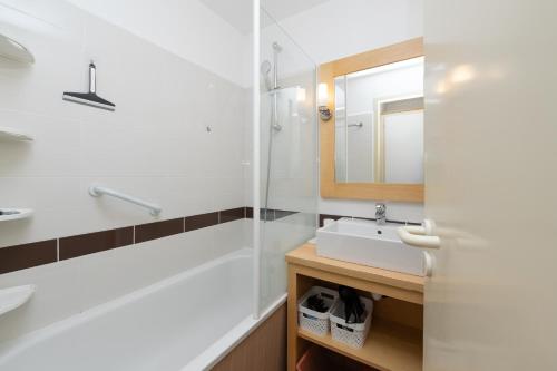 a bathroom with a sink and a mirror at Appartement 4p - piscine partagée in Arzon