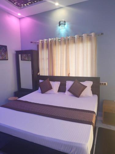 a bedroom with a large bed with purple walls at Rawat ji Homestay in Rāmnagar