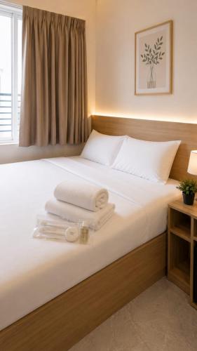 a bedroom with a bed with towels on it at Merryland ICE BSD City in Tjilandak