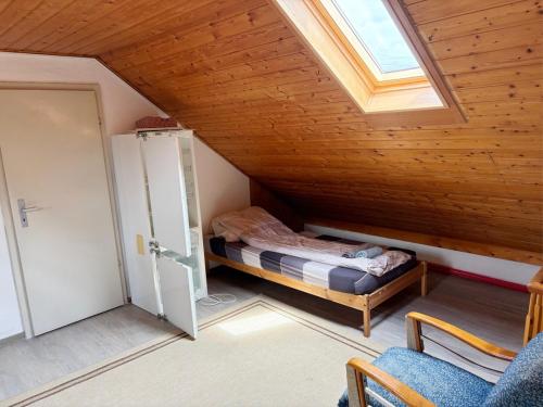 a attic room with a bed and a window at Monteurhaus in Giengen an der Brenz-Burgberg in Giengen an der Brenz