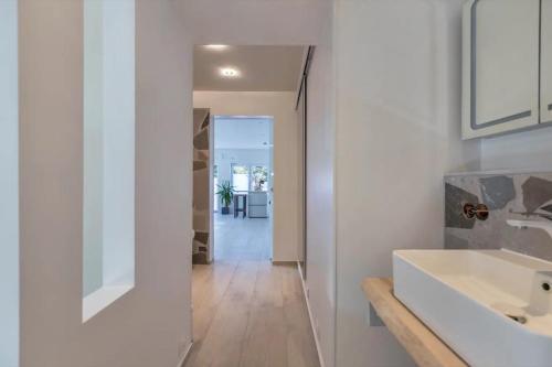 a white bathroom with a sink and a mirror at Uhse Ferienwohnung Delux mit Loft in Heide