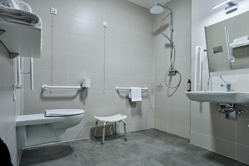 a bathroom with a toilet and a sink and a shower at Hotel Nowa Bukowa in Katowice
