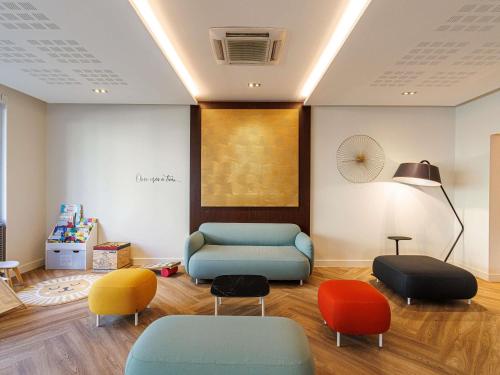 a waiting room with colorful chairs and a couch at Adagio Nice Centre in Nice