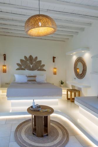 ein Schlafzimmer mit einem Bett und einem Tisch in einem Zimmer in der Unterkunft Anthea Hotel in Tinos