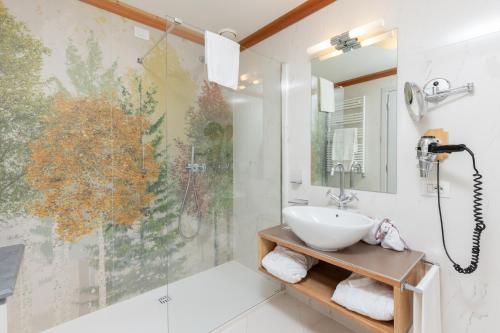 a bathroom with a sink and a shower at QC Grand Hotel Bagni Nuovi in Bormio