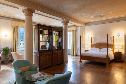 a bedroom with a bed and a table and chairs at QC Grand Hotel Bagni Nuovi in Bormio