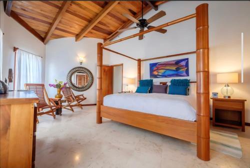 a bedroom with a canopy bed with blue pillows at Indigo Belize Beach 2C in San Pedro