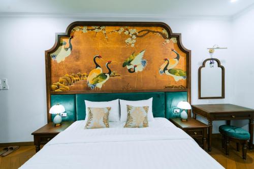 a bedroom with a large bed with a painting on the wall at OCEAN HOTEL Ninh Binh - Near Trang An & Hoa Lư Old Town in Kỳ Vĩ