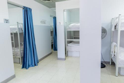 a room with two beds and blue curtains at New Gate Hostel in Jerusalem
