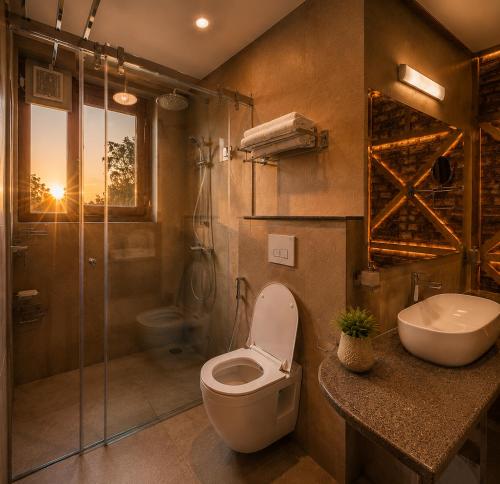 a bathroom with a toilet and a sink and a shower at The Riverside Barn Srinagar in Srinagar