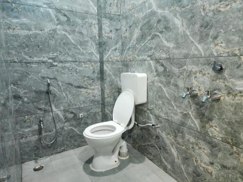 a bathroom with a toilet in a stone wall at Hotel Navin Palace Pirpainti in Bhāgalpur
