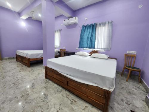 two beds in a room with purple walls at Hotel Navin Palace Pirpainti in Bhāgalpur