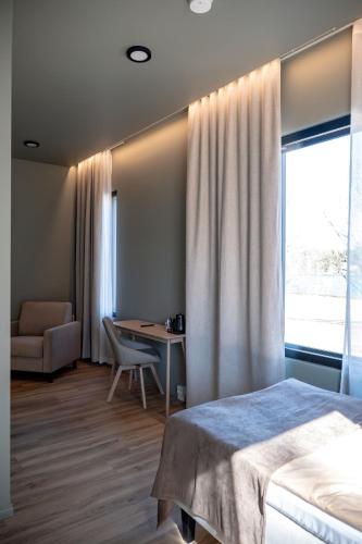 a bedroom with a bed and a desk and a window at Ruustinna Hotelli & B&B Majoitus in Saarijärvi