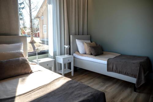 a bedroom with two beds and a window at Ruustinna Hotelli & B&B Majoitus in Saarijärvi