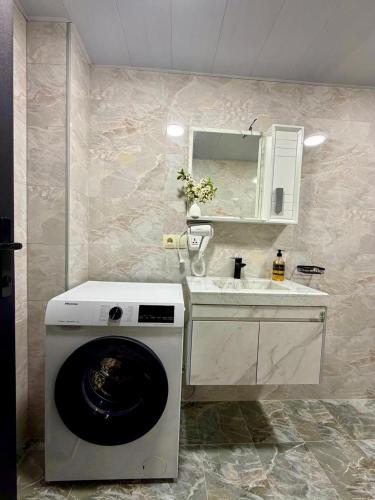 a bathroom with a washing machine and a sink at Grand Hills Kazbegi in (( Gergeti ))