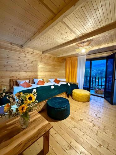 a room with a bed and two ottomans at Grand Hills Kazbegi in (( Gergeti ))