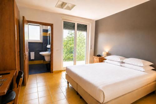 ein Schlafzimmer mit einem großen Bett und ein Badezimmer in der Unterkunft Phi Hotel Homy Druento in Druento