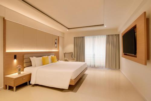 a hotel room with a bed and a television at Regenta Place CG Road in Ahmedabad