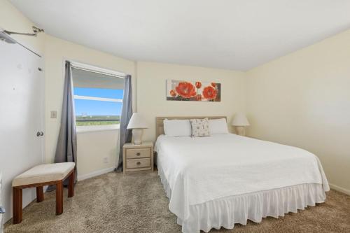 a white bedroom with a bed and a window at Perdido Sun 1008 in Perdido Key