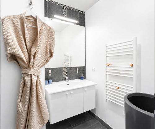 a white bathroom with a sink and a mirror at Porte de Paris, spacieux T3, terrasse et parking in Vanves