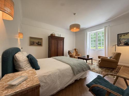 a bedroom with a large bed and chairs in it at Gure gostuan in Itxassou