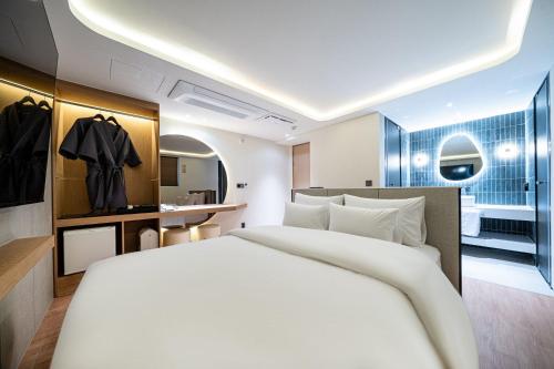 a bedroom with a large white bed and a bathroom at 천호 호텔 코드 in Seoul