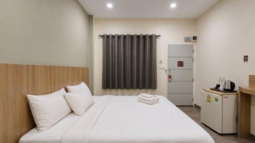 a bedroom with a large bed with white pillows at Beyond 21 Hotel in Khon Kaen
