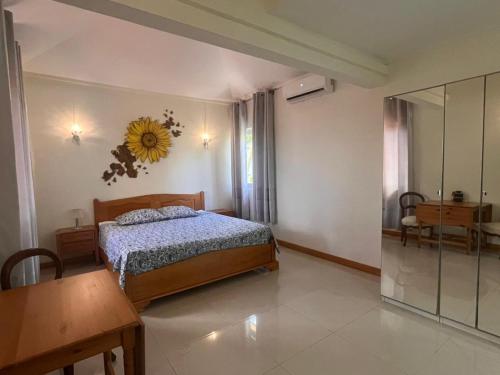 a bedroom with a bed with a sunflower on the wall at Blacvine in La Gaulette