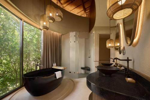 a bathroom with two sinks and a large window at dusitD2 Khao Yai in Mu Si