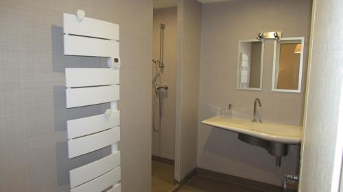 a bathroom with a sink and a shower at Auberge Les Volcans in Murat