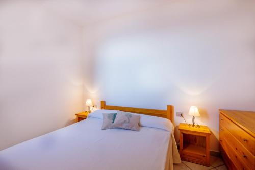 哥斯達黎加天堂的住宿－Paradiso，一间卧室配有一张带两盏灯的大型白色床。