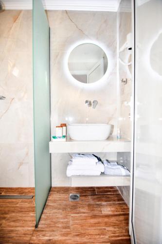 a bathroom with a sink and a mirror at EXOHI STUDIOS in Sarti