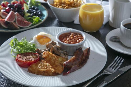 a plate of breakfast food with eggs bacon beans and vegetables at Hotel Collingwood BW Signature Collection in Bournemouth