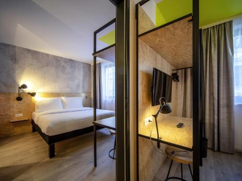 a hotel room with a bed and a mirror at ibis Styles Wien Messe Prater in Vienna