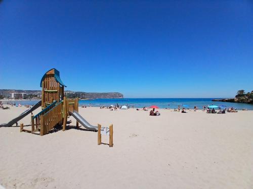 a playground on a beach with a group of people at Villa Gota de Mar in Jávea