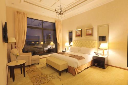 a bedroom with a bed and a chair and a window at Getfam Hotel in Addis Ababa