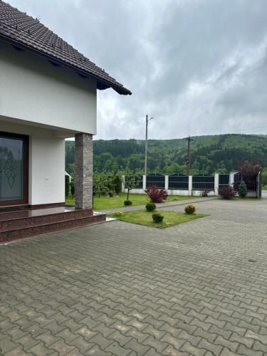 a house with a brick driveway next to a building at Casa Tică in Vama Buzăului