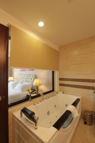 a bathroom with a tub with a bed in the mirror at Getfam Hotel in Addis Ababa