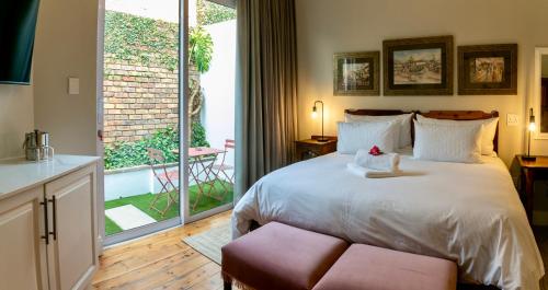 a bedroom with a bed and a large window at Murray Street 137 Guesthouse in Pretoria