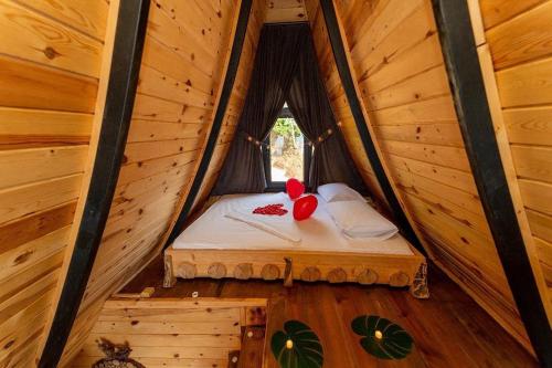 a bed in a wooden cabin with a window at Himora Suit Bungalov in Ardeşen
