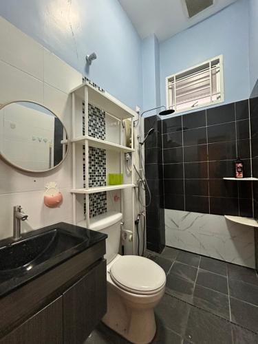 a bathroom with a toilet and a sink and a mirror at NovaStay Melaka in Kampong Kerubong