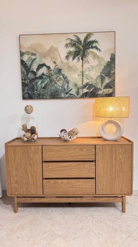 a wooden dresser in a room with a painting on the wall at Villa Nueva Martinique in Gros-Morne