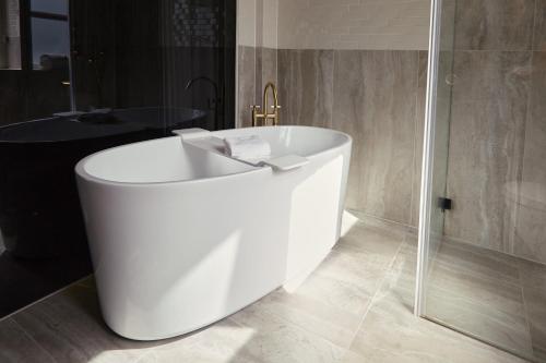a white bath tub in a bathroom with a shower at Ascot Hotel in Copenhagen